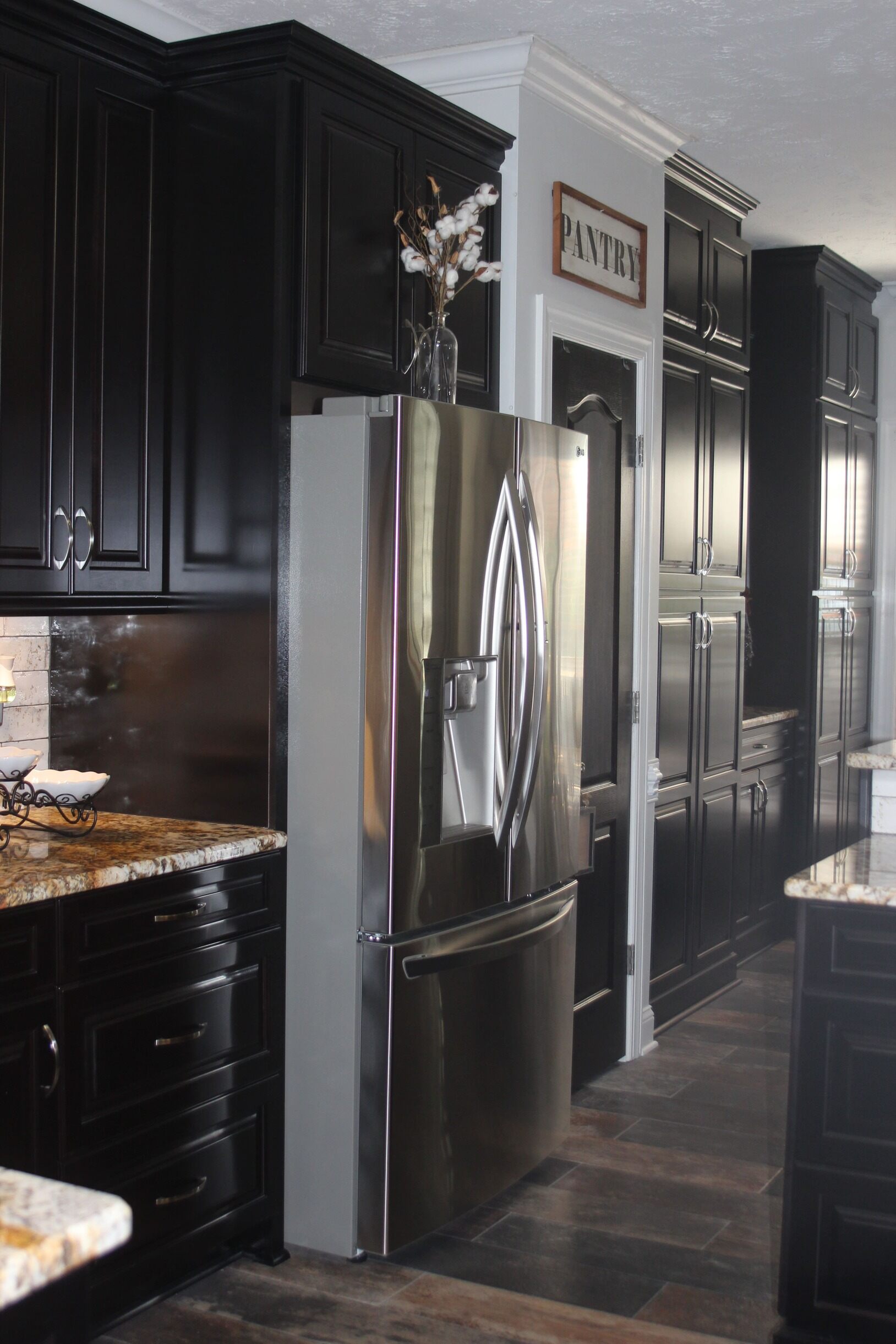Black kitchen cabinets and silver fridge