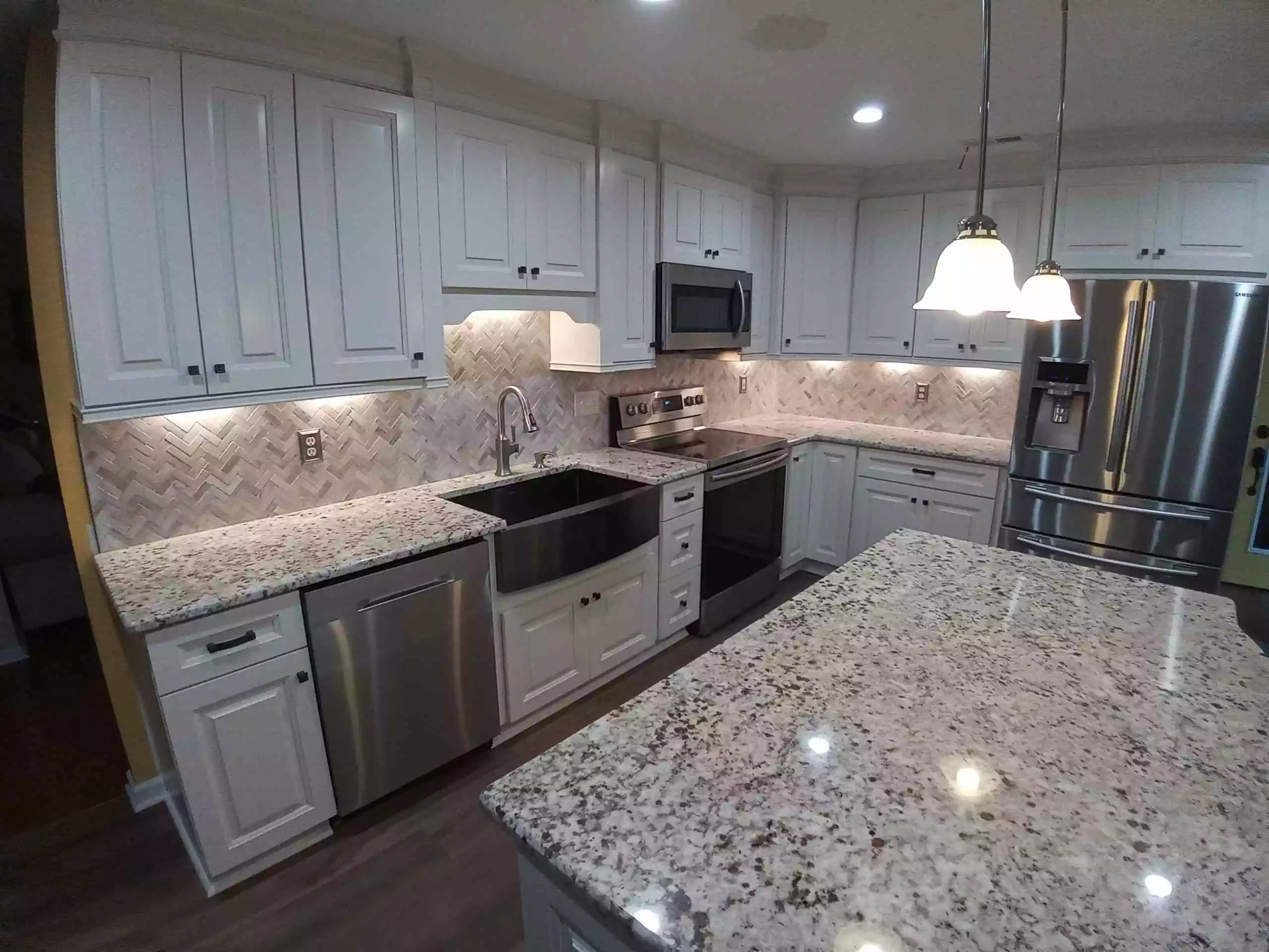 White kitchen cabinets with granite countertops.