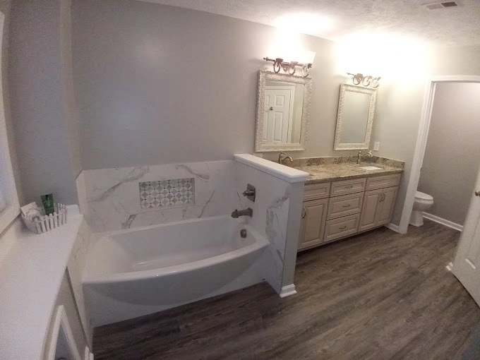 Beautiful bathroom remodel with white bathtub and custom perla cabinets