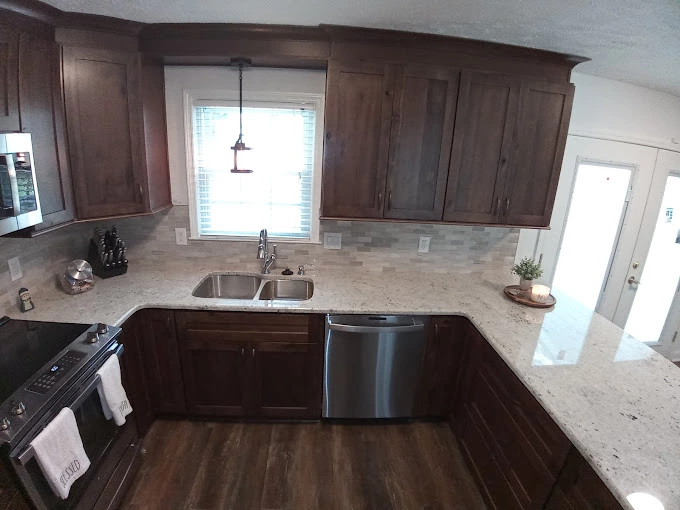 Beautiful kitchen remodel with brown cabinets and white countertop and silver kitchen applicances