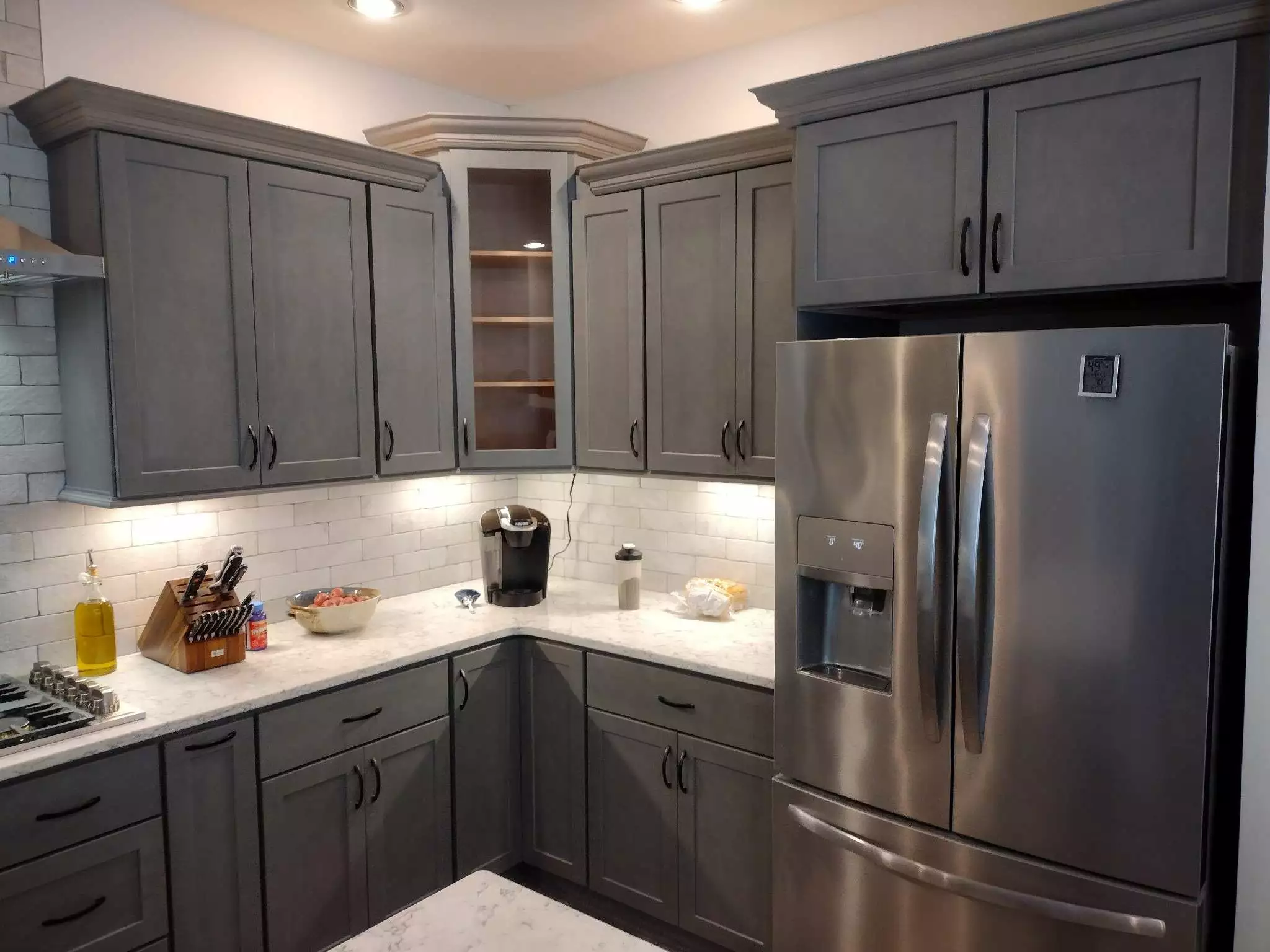 Grey kitchen cabinets with white countertop style. 