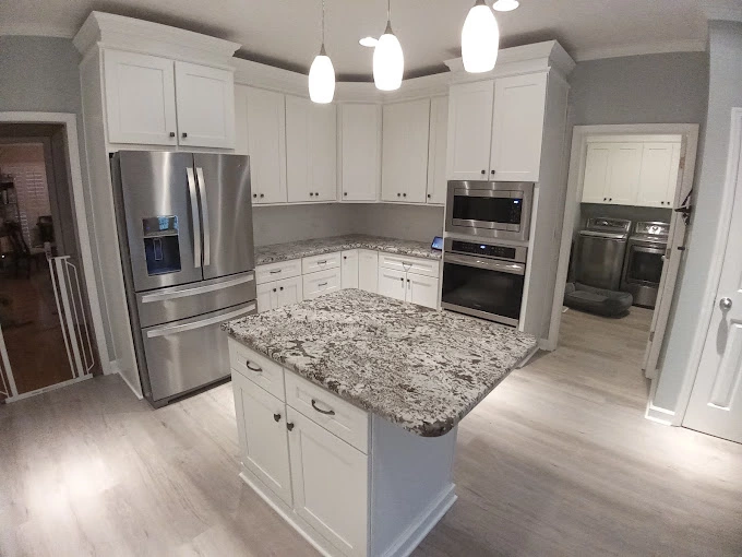 Custom countertop with silver fridge and ovens and island in kitchen remodeling project