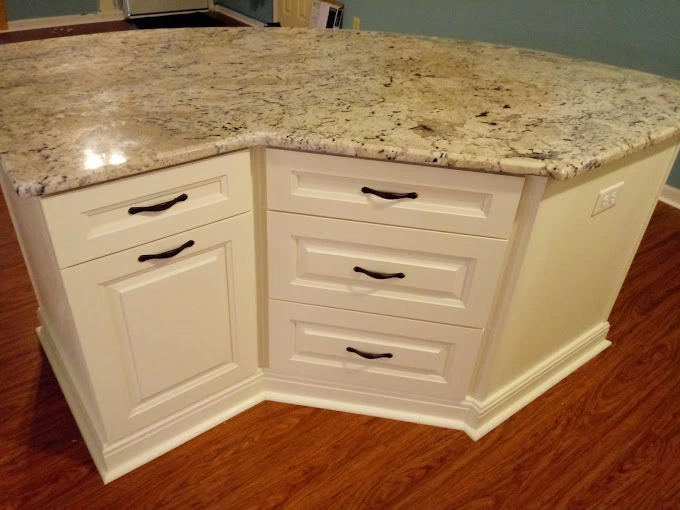 Finished custom kitchen island after construction has been completed that has white kitchen cabinets.