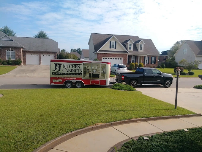 J&J Kitchen Cabinets work truck with logo in front of house.