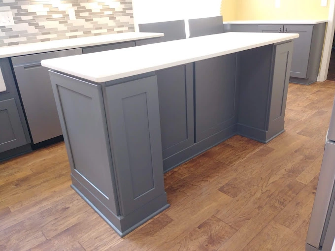 Long custom kitchen island with white countertop.