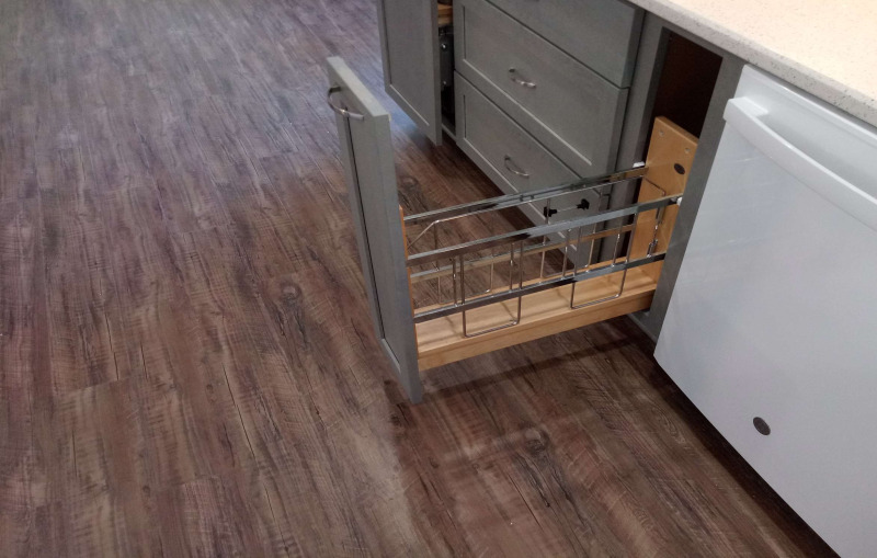 Spice rack pull out cabinet near dish washer.