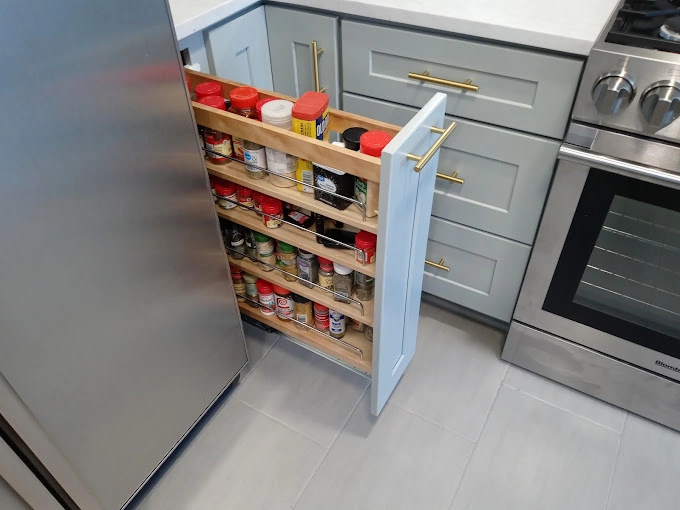 Custom kitchen cabinet spice rack pull out that is full of a variety of spices. 